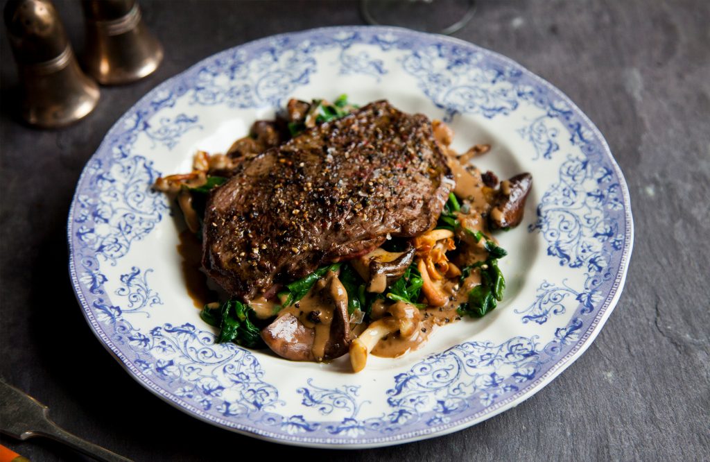 Entrecôte en croûte de poivre, épinards et champignons sauvages